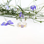 A sterling silver ring with a square amethyst stone.
