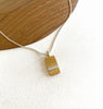 A gold band pendant necklace with a rectangular gold-plated base and a horizontal band, displayed on an adjustable silver chain 