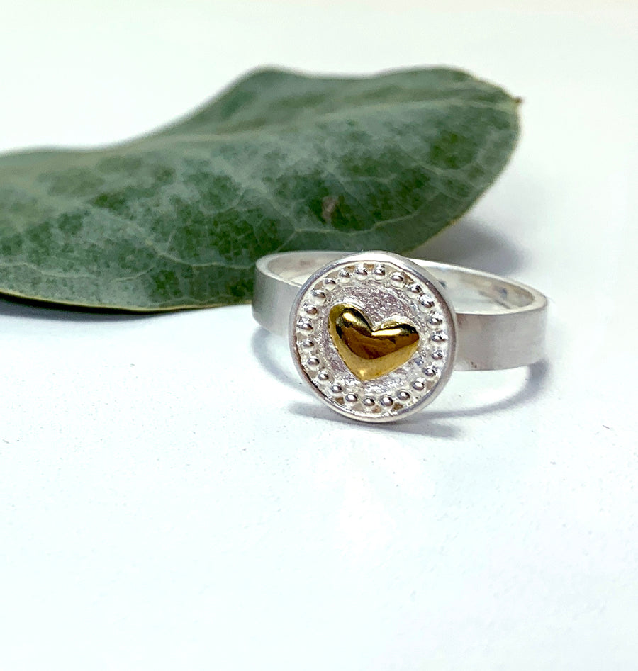 made from 925 sterling silver. Extra fine dots border the outer circle with the centre raised heart shape carefully moulded from yellow alpha brass.